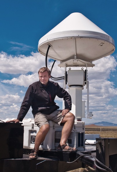 Radek Goska sitting on a radar instrument