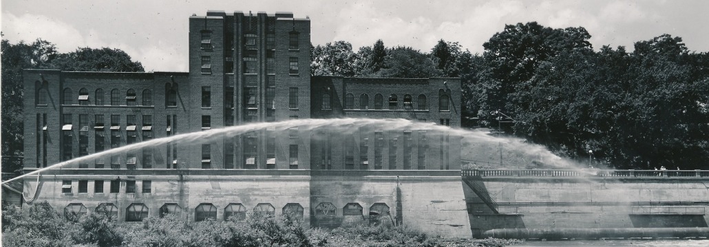 SHL with a fire hose spouting in front of it, shot from the river
