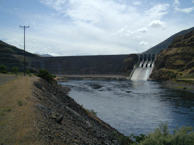 looking up towards Brownlee dam from downstream, with a body of water in front