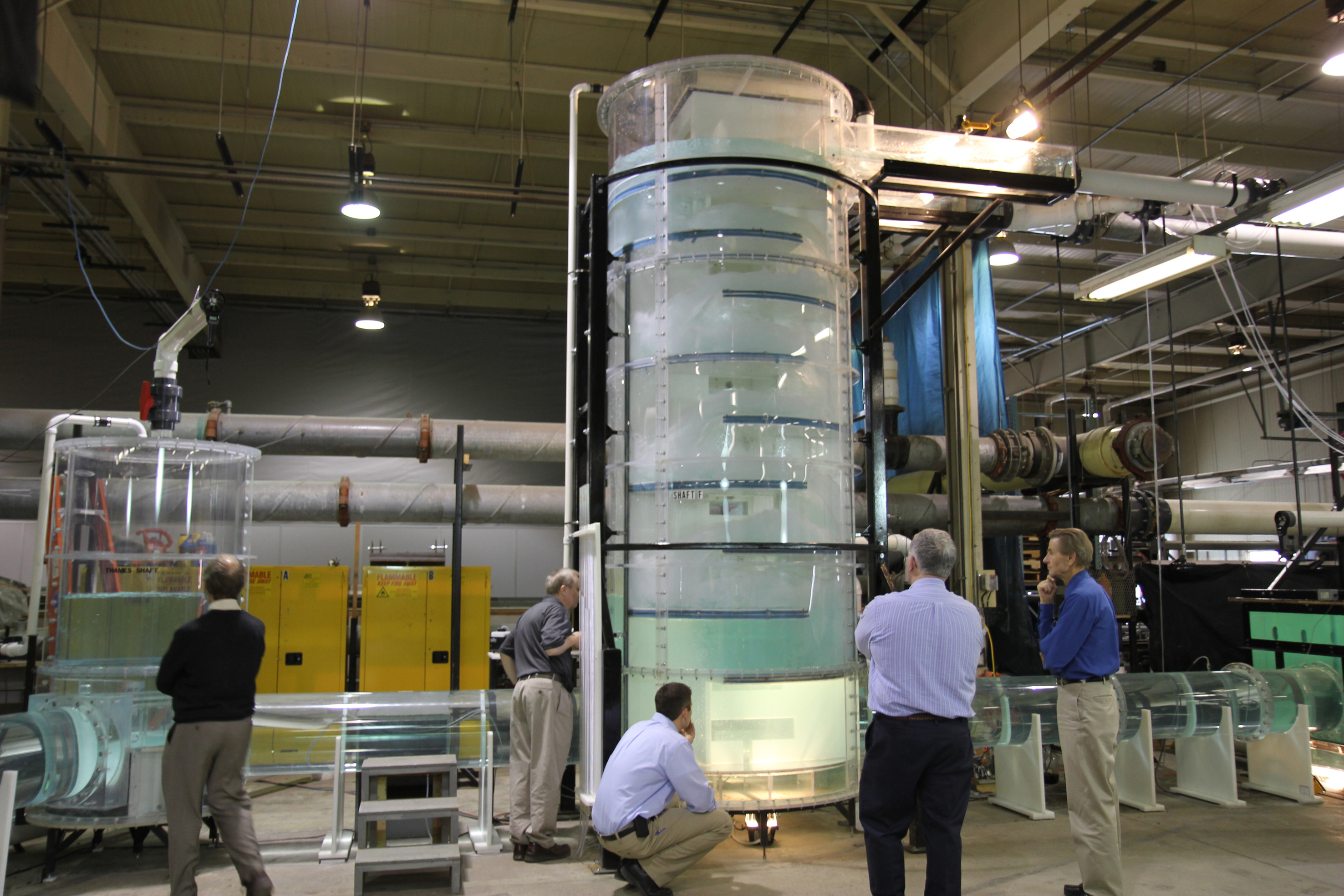 Engineers gather around a dropshaft model to survey it in IIHR's modeling facility
