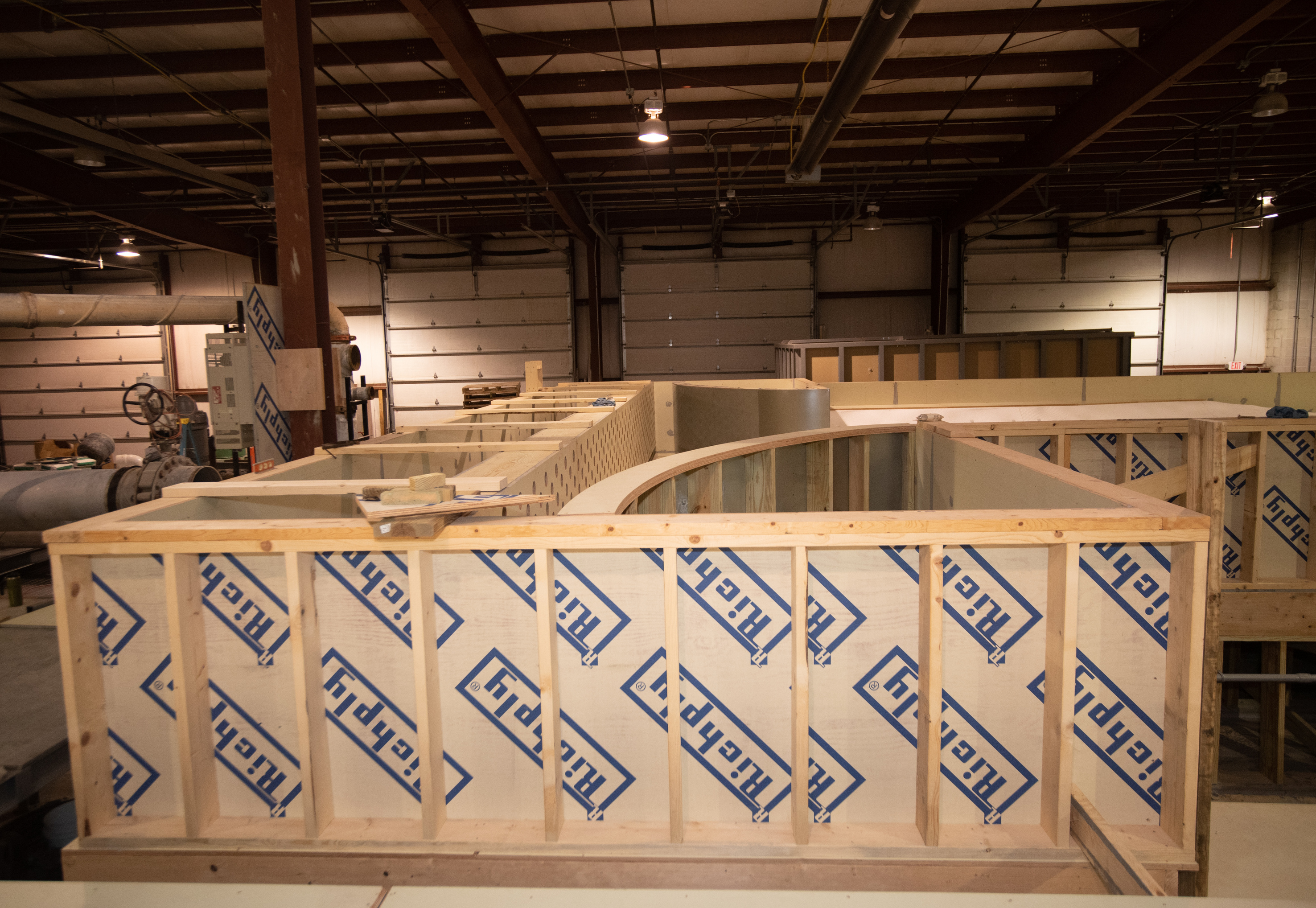 A wooden model in a large warehouse modeling facility