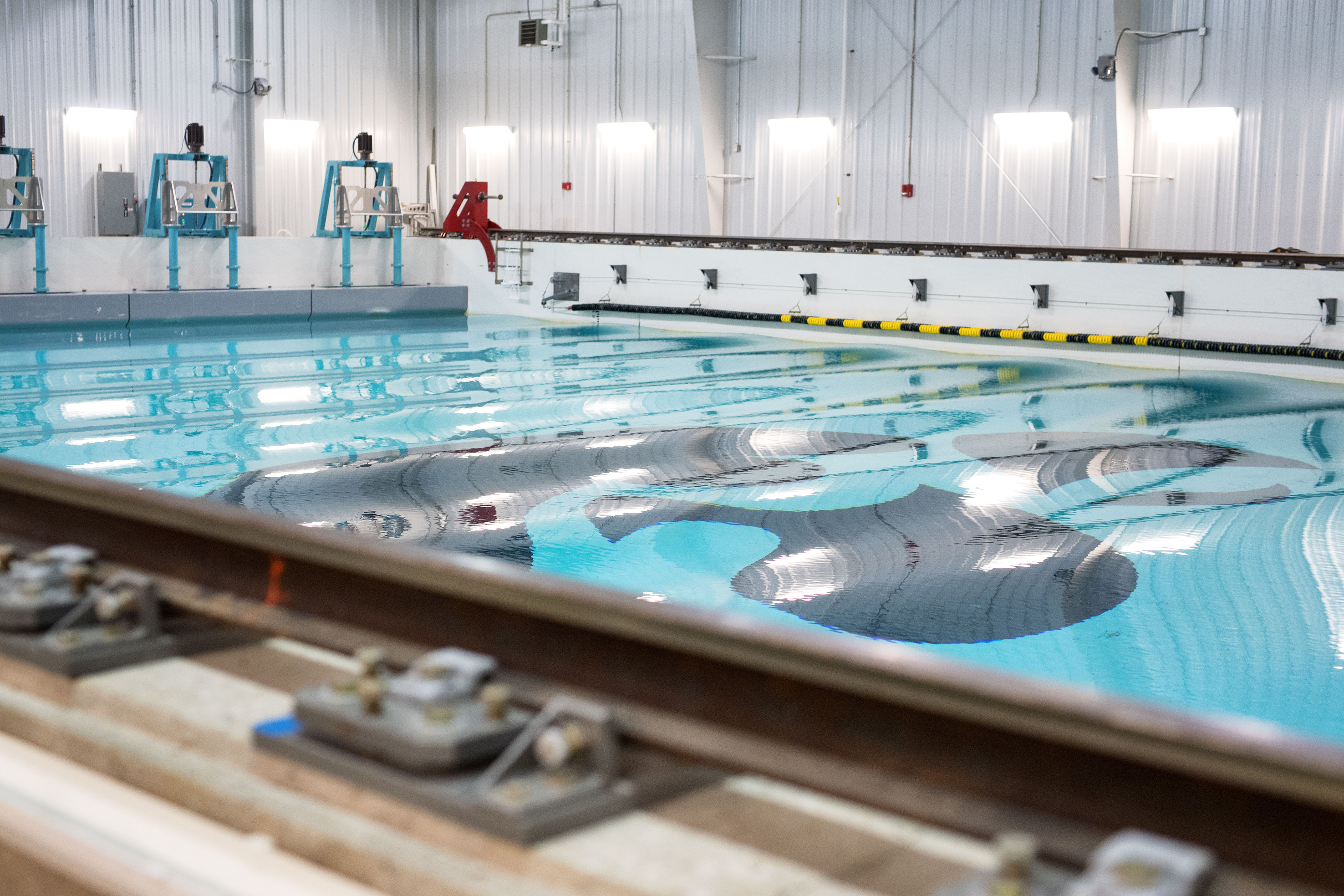 the pool at the IIHR wave basin facility, with small waves being generated by the wave makers pictured in the back