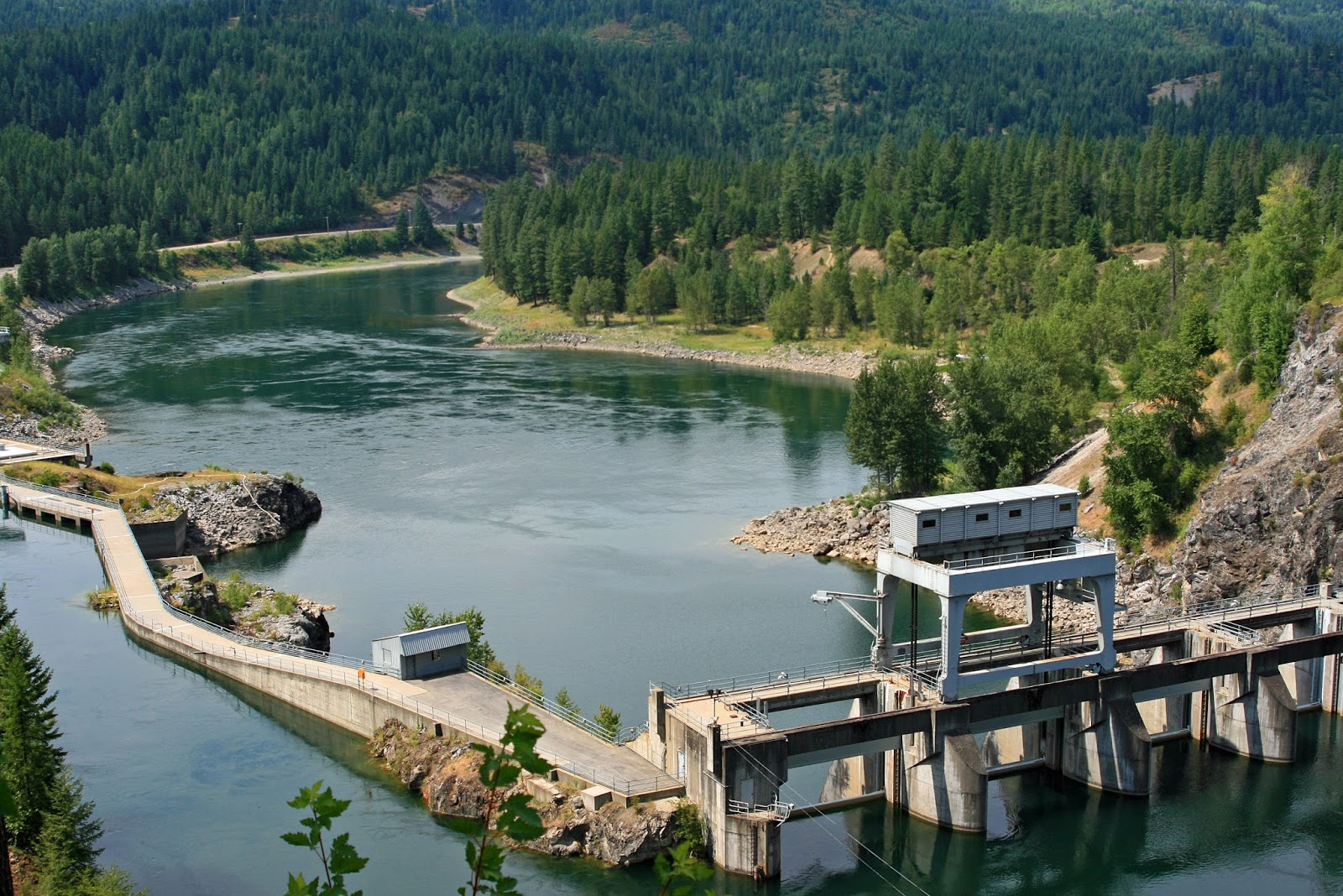 Box Canyon Dam from above, with clear blue waters flowing through the surrounding mountain
