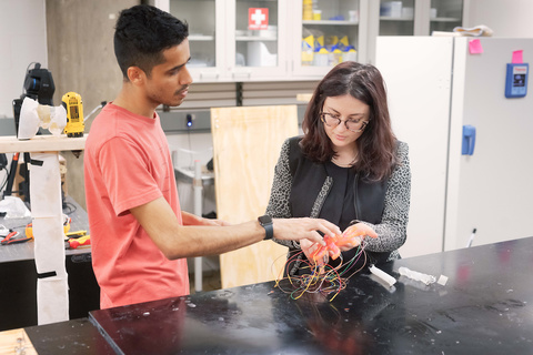 Caterina Lamuta works with a student in her lab