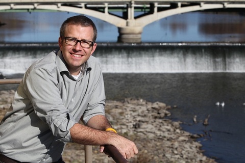David Cwiertny poses for a photo by the Iowa River