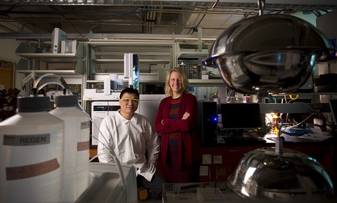 Keri Hornbuckle poses for a photo with a researcher in her lab