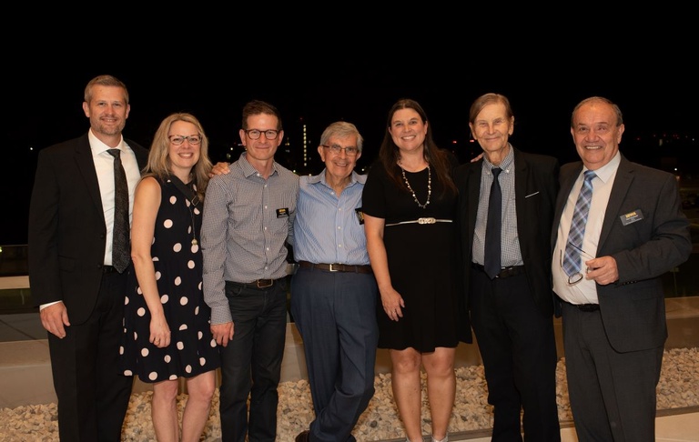 Seven people pose for a photo