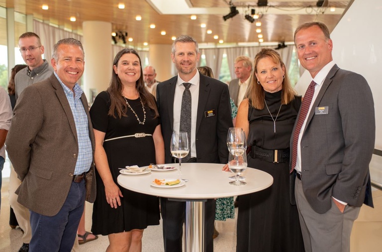 Five people pose for a photo