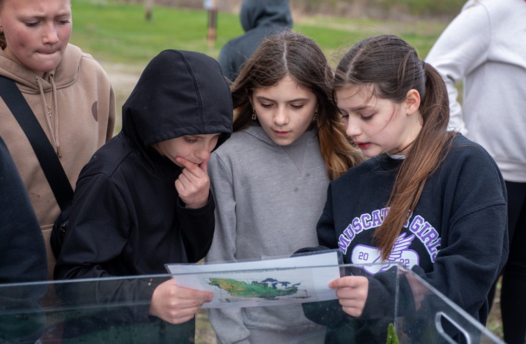 Kids review a watershed map to help illustrate the LACMRERS area