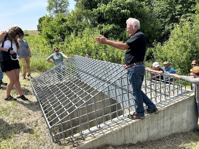 a group of people check out an on road structure on a steep hill