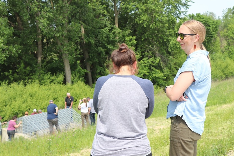 two people chat in the foreground, with a group below looking at on road structures
