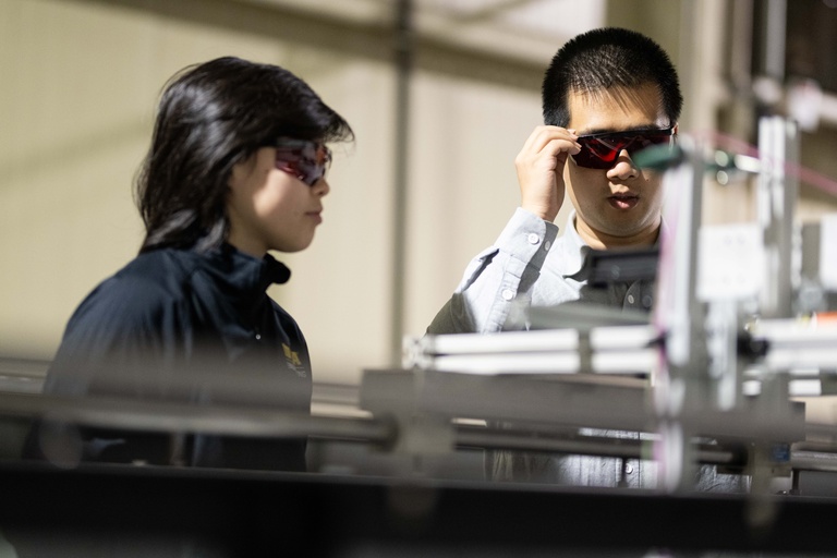 IIHR students with eye protection from the Wang research group conduct research on a flume