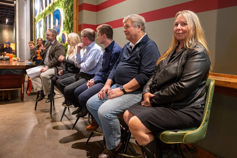 The panel of scientists for the CISWRA presentation sit in a line on green leather swivel chairs.