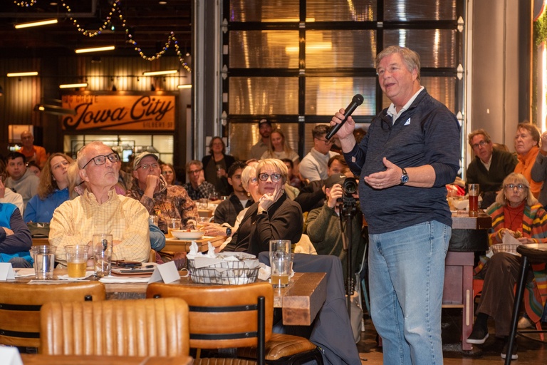 Jerry Schnoor addresses the crowd with the microphone while standing