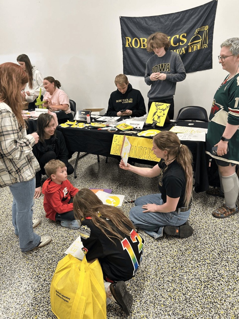 the robotics team has kids crowded around, making herky logos