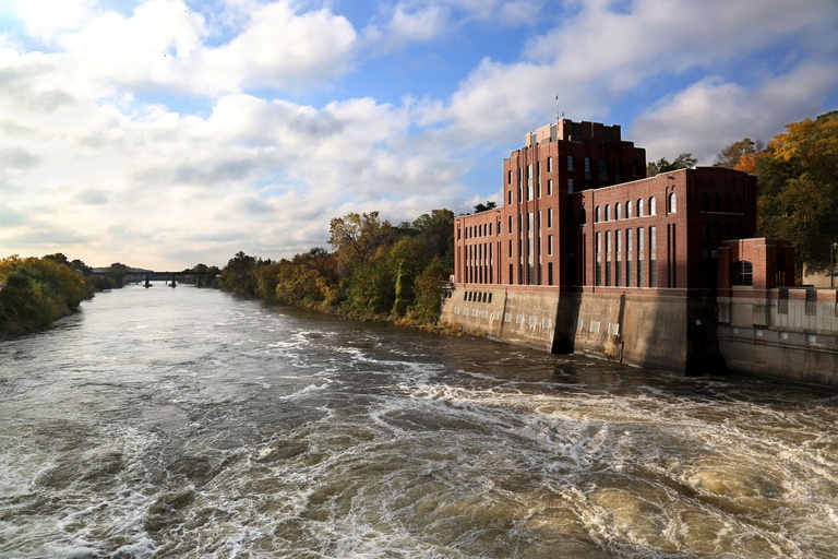 Five-story red brick building on the banks of a river