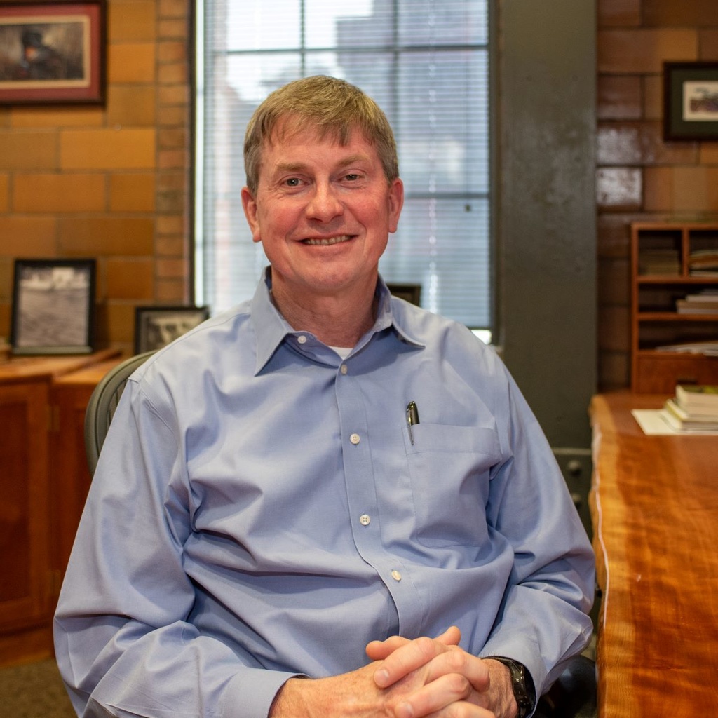 Larry Weber poses for a photo in his office