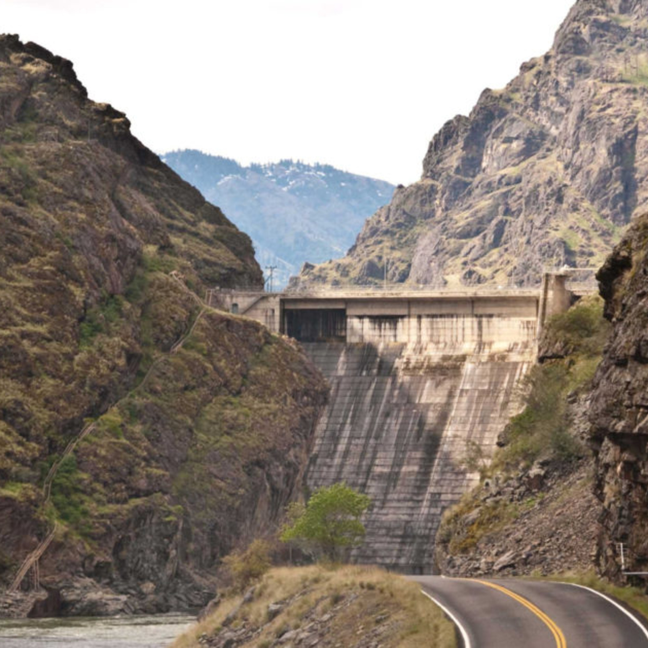 A picture of hells canyon dam, with rocky mountainous terrain surrounding 
