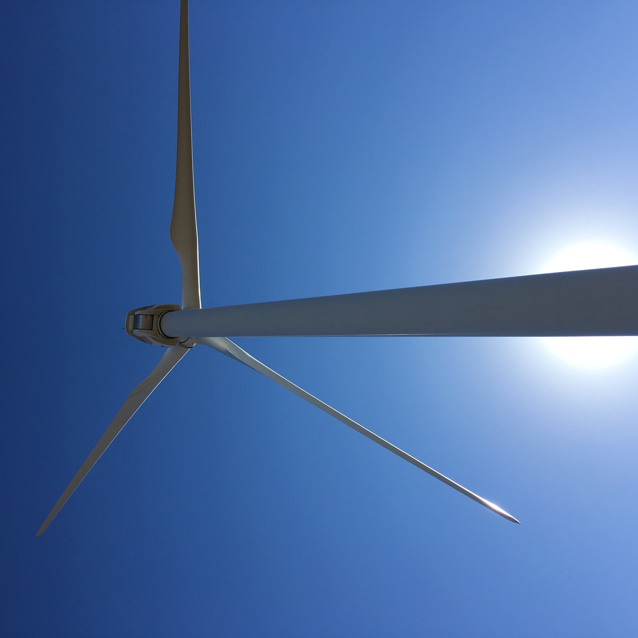 a wind turbine against a sunny sky