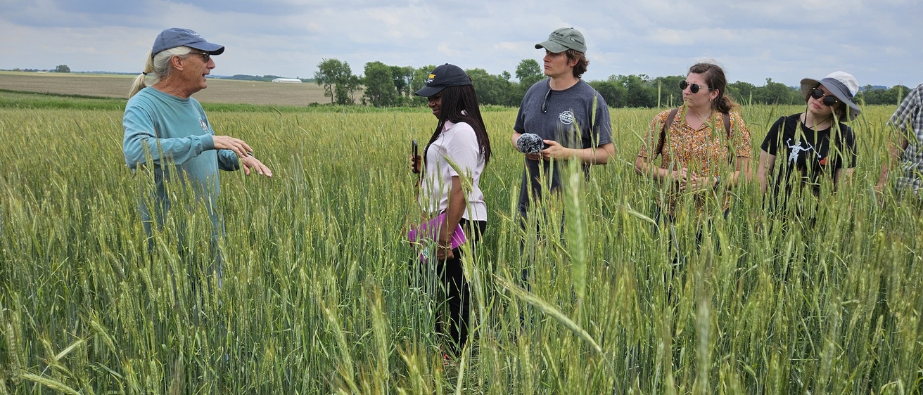 BlueGAP students stand in the farmer Dick Sloan's field, learning about nitrate runoff 
