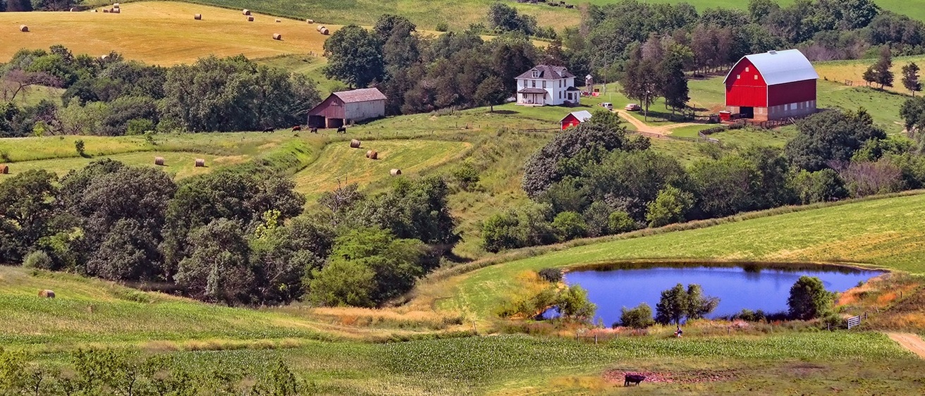 a picturesque farm house sitting on rolling green Iowan hills
