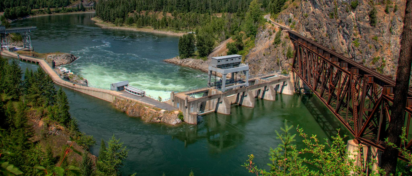 Box Canyon Dam from above, with clear blue waters flowing through the surrounding mountain