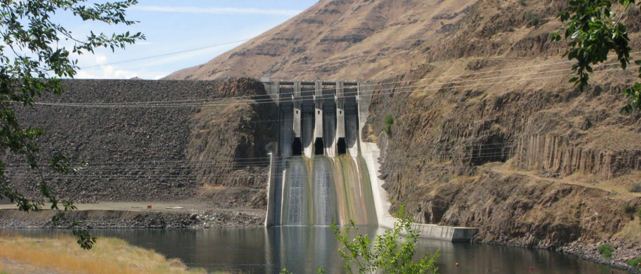 A picture of Brownlee Dam, with water slowly pouring from the outlet