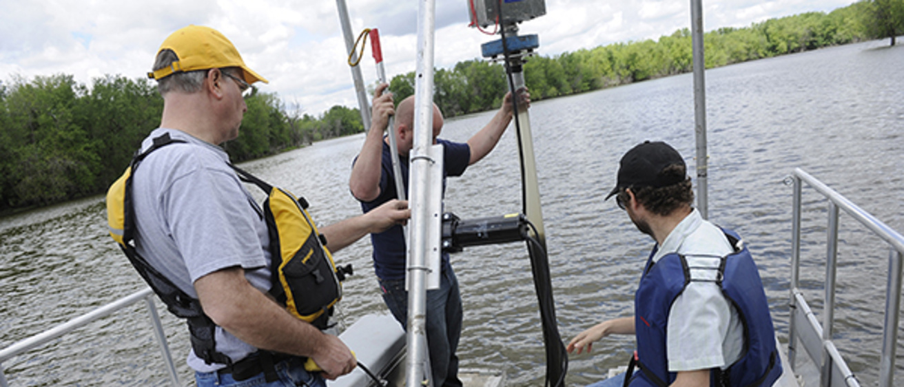 IIHR researchers on a boat, working on coring