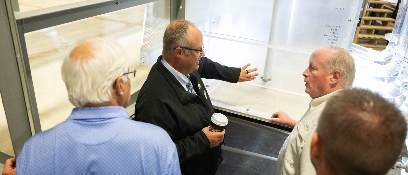 A touring group looks at the Bee Branch model in IIHR's facilities, discussing