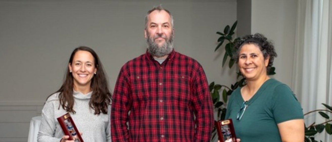 3 award recipients stand in a line and smile, holding their 10-year awards