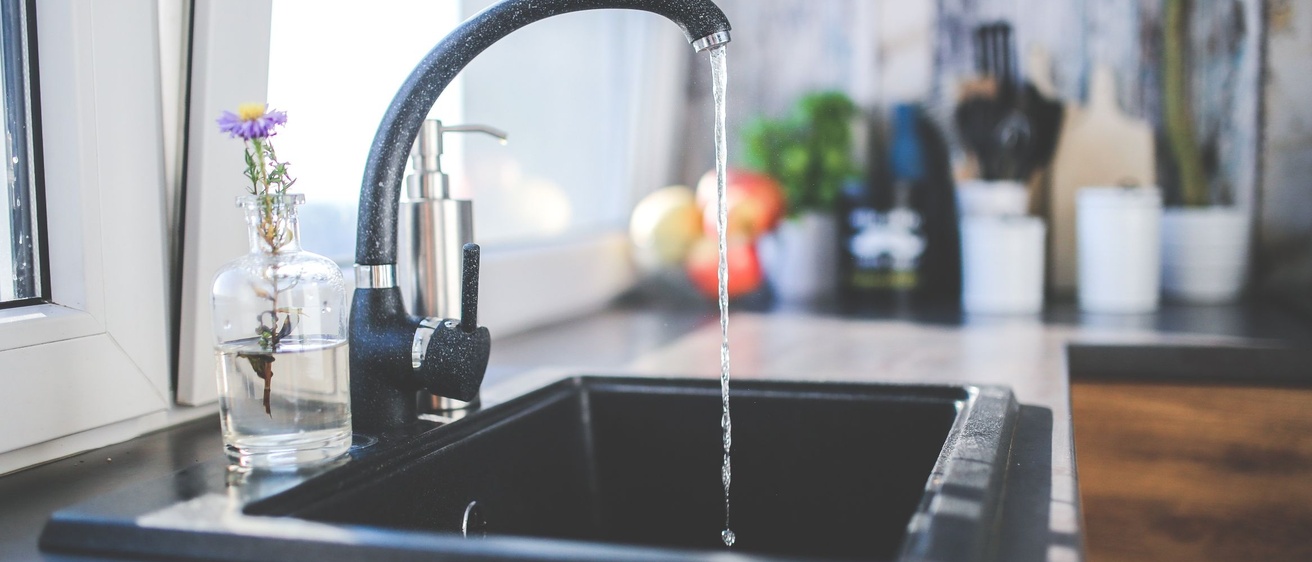 A kitchen faucet with water running