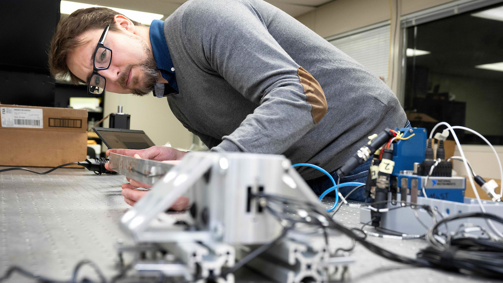 Casey Harwood works with equipment in his lab
