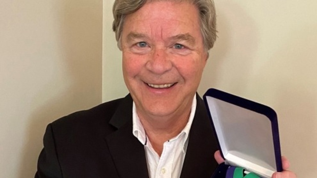 Schnoor poses with an award