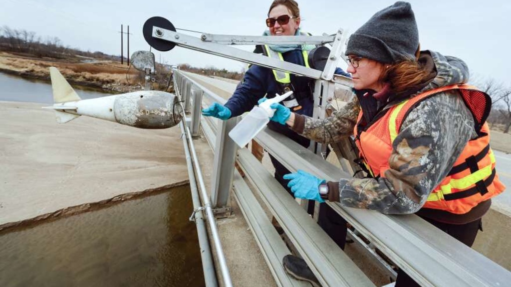 A scientist collects a water sample