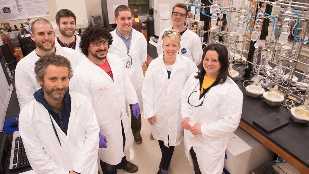 A group of men and women in white lab coats