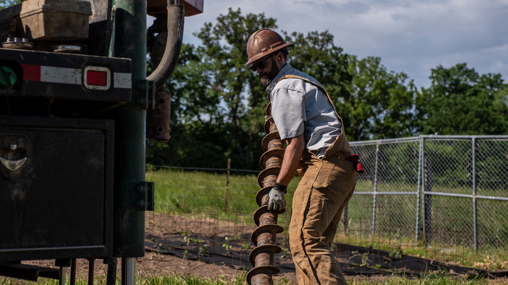 an IGS worker carries a drill to the drilling rig in order to get coring samples