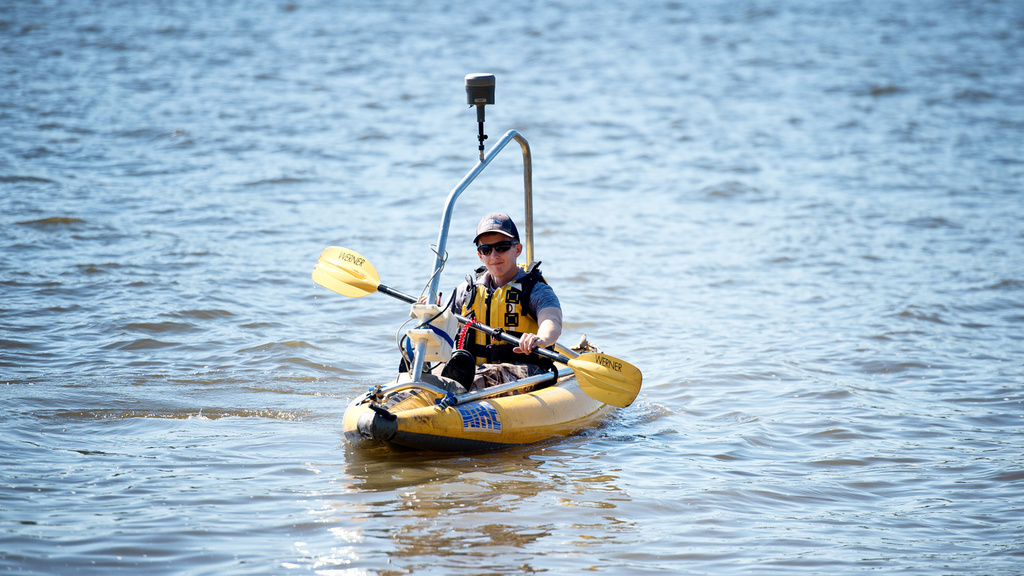 An IFC researcher uses a research kayak to chart bathymetry in an Iowan river