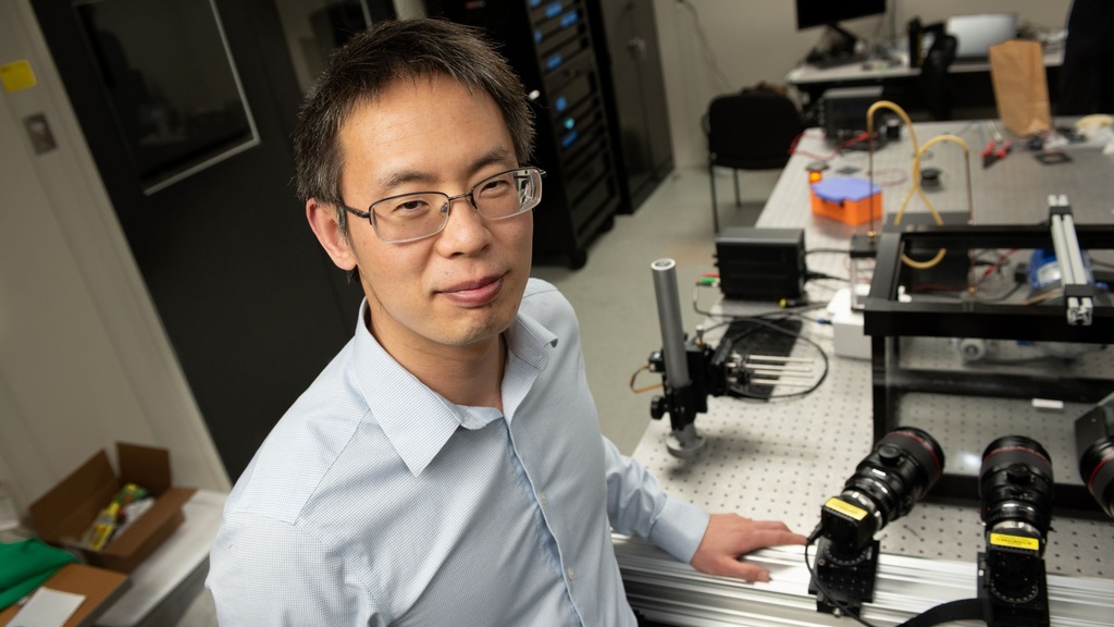 A man in glasses poses in a laboratory