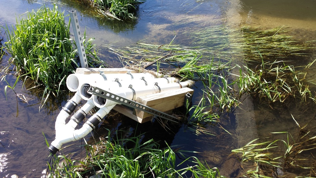 White PVC tubing protects water quality sensors in an Iowa stream